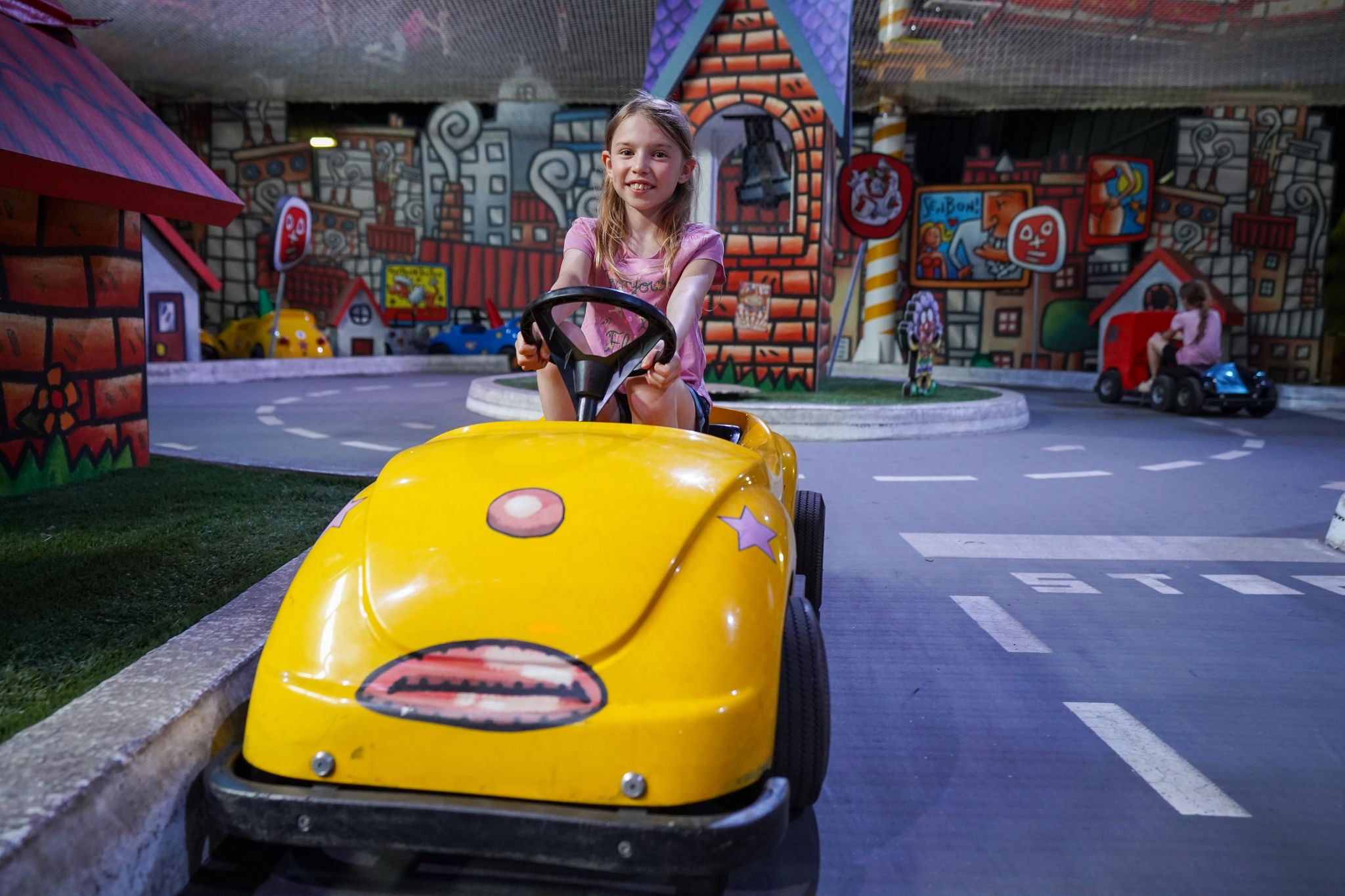 Girl riding a toy car at France miniature 