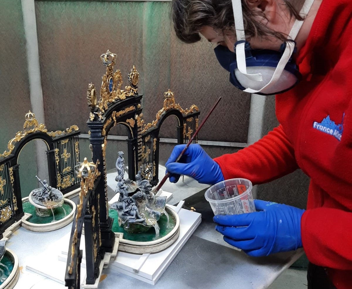 France Miniature employee working on the gates of place stanislas 